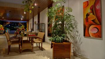 A dining area with wooden furniture and a large potted plant.