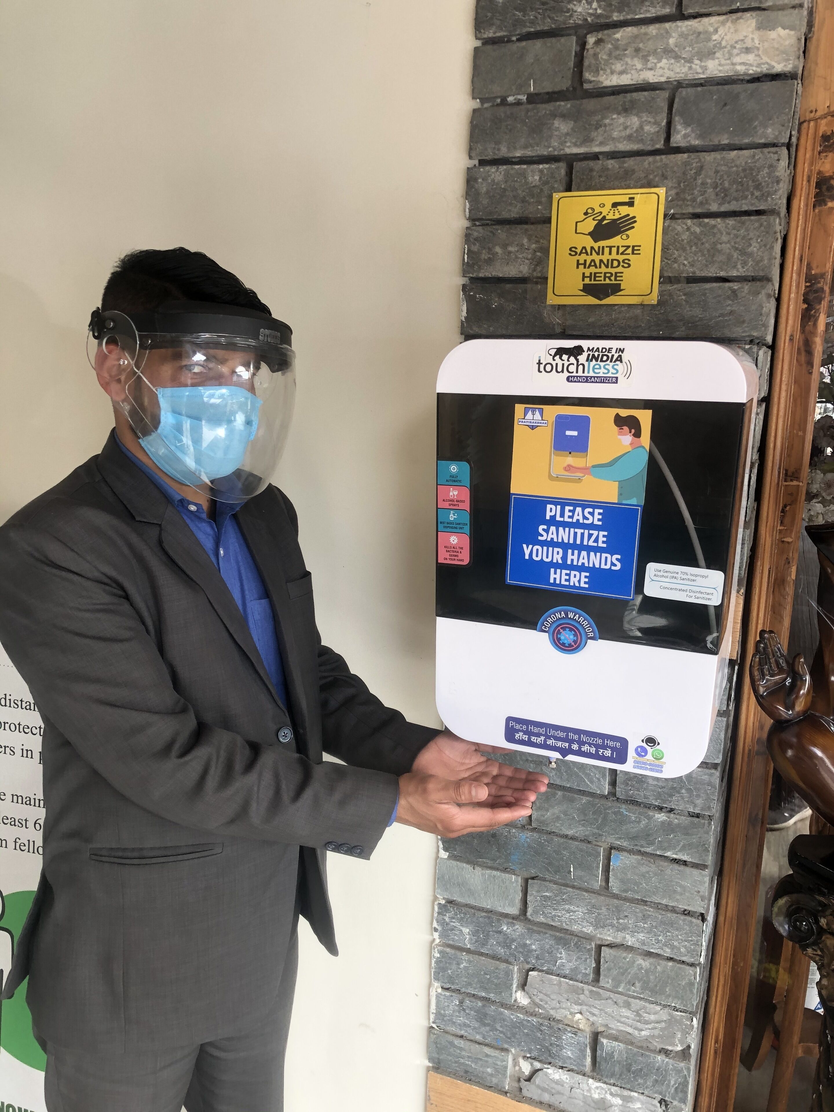 A person holding a hand sanitizer dispenser with instructions to sanitize hands.