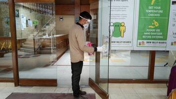 A person cleaning a glass door at a resort entrance.