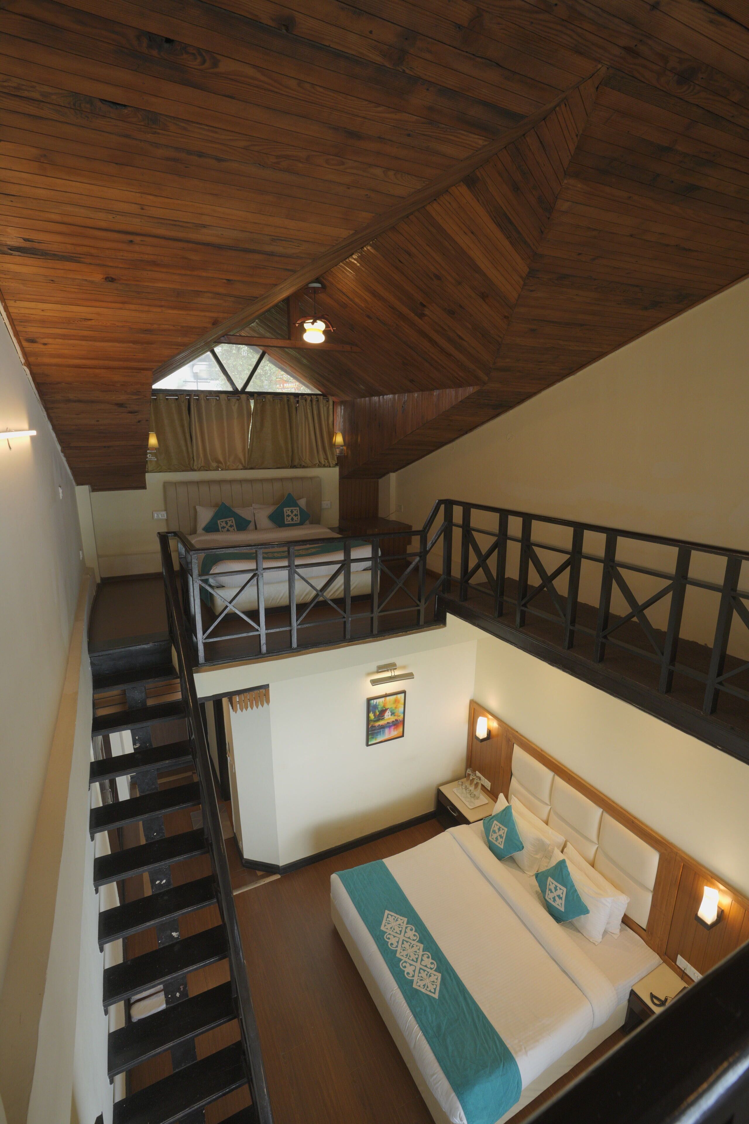 A bedroom with a loft bed, a staircase, and a view of the outdoors.
