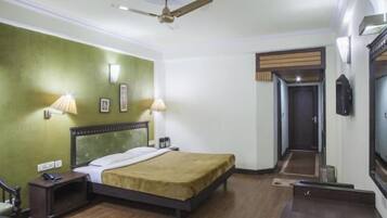 A hotel room with a bed, bedside lamps, a telephone, and a ceiling fan.