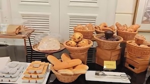 Un bufé con diversas opciones de panadería, incluyendo panes, pasteles y tortas.