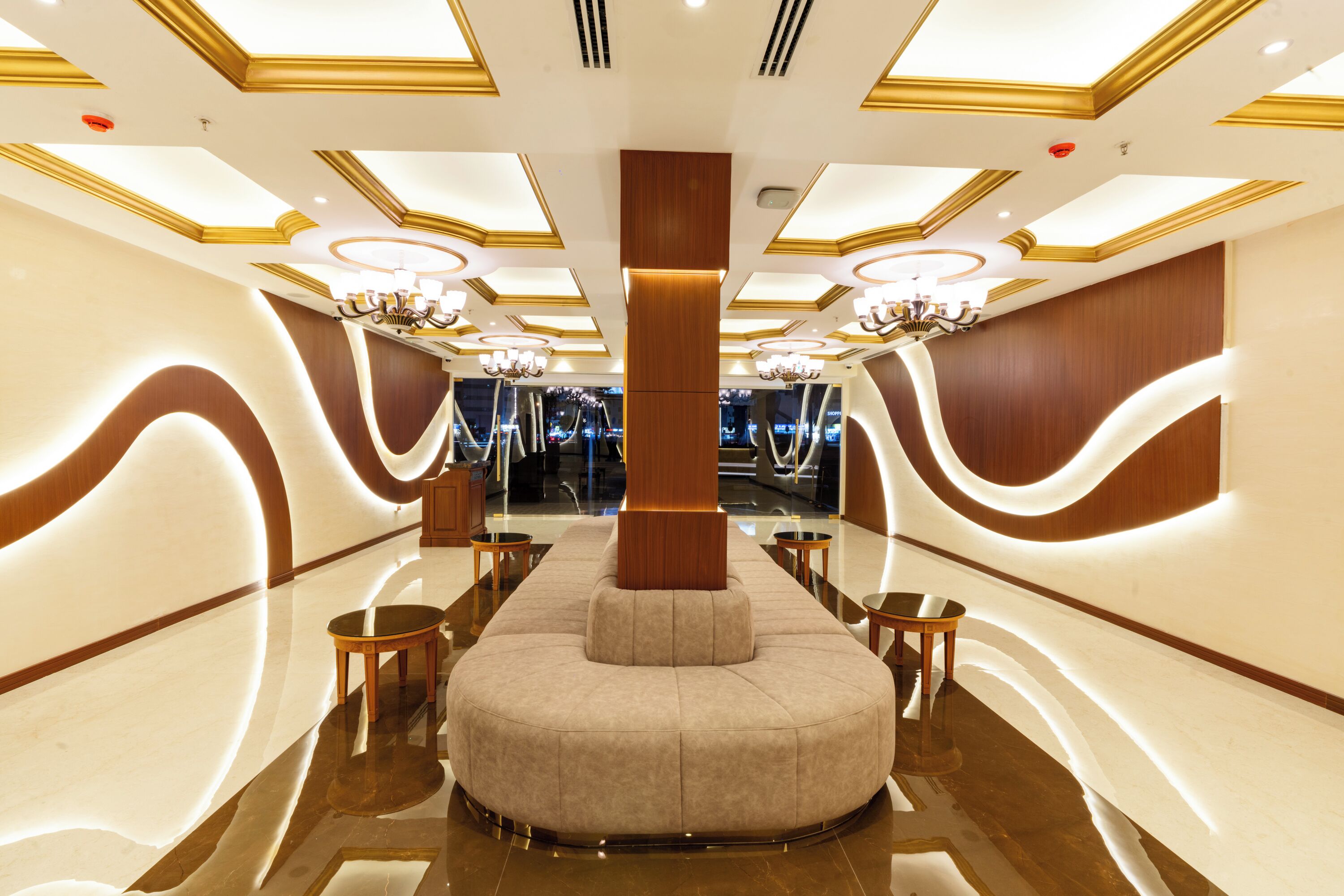 Eine geräumige, moderne Lobby mit einer zentralen Sitzgruppe, stilvollen Kronleuchtern und einem glänzenden Boden.
