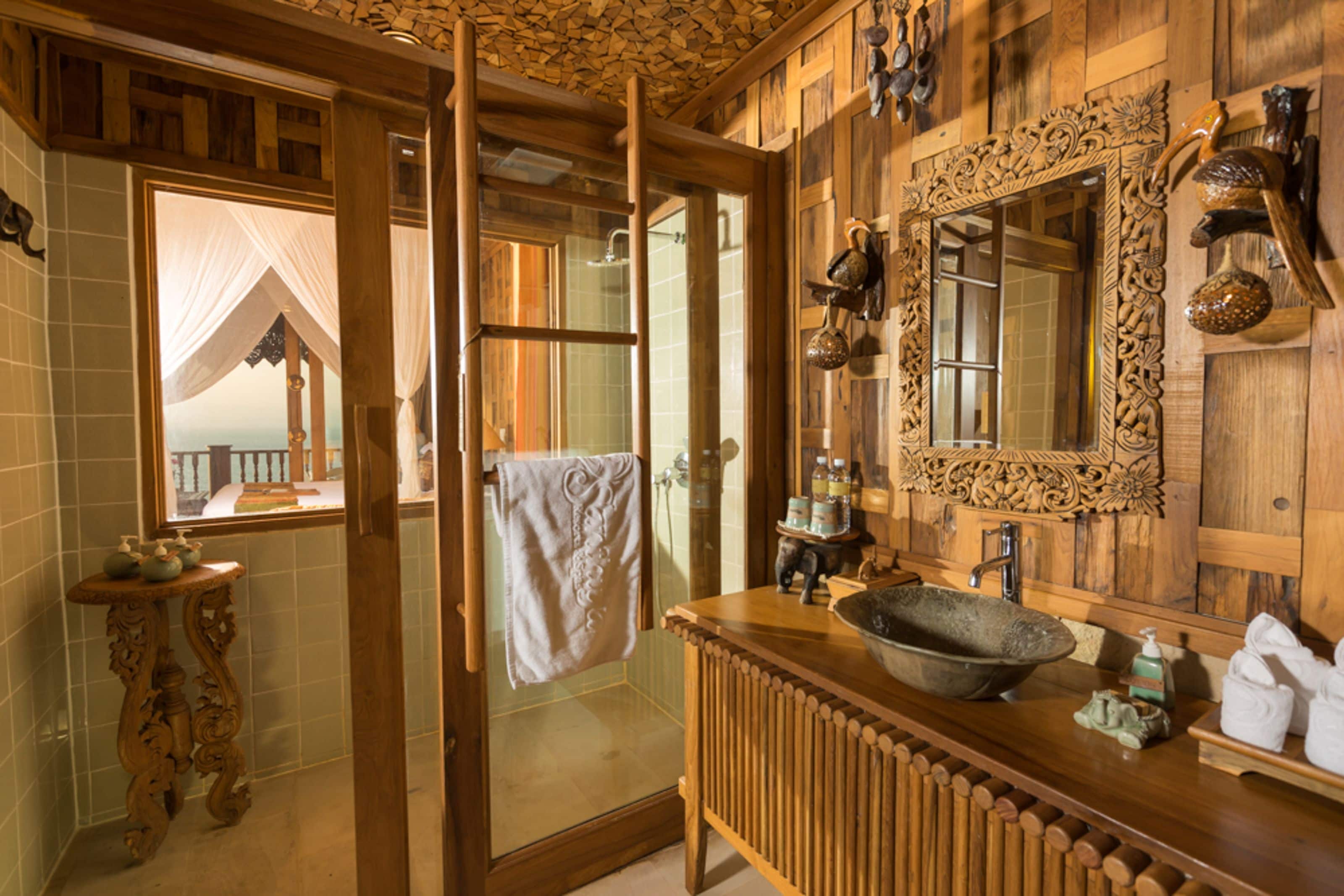 Une salle de bain avec un meuble-lavabo en bois, un grand miroir et une cabine de douche en verre.