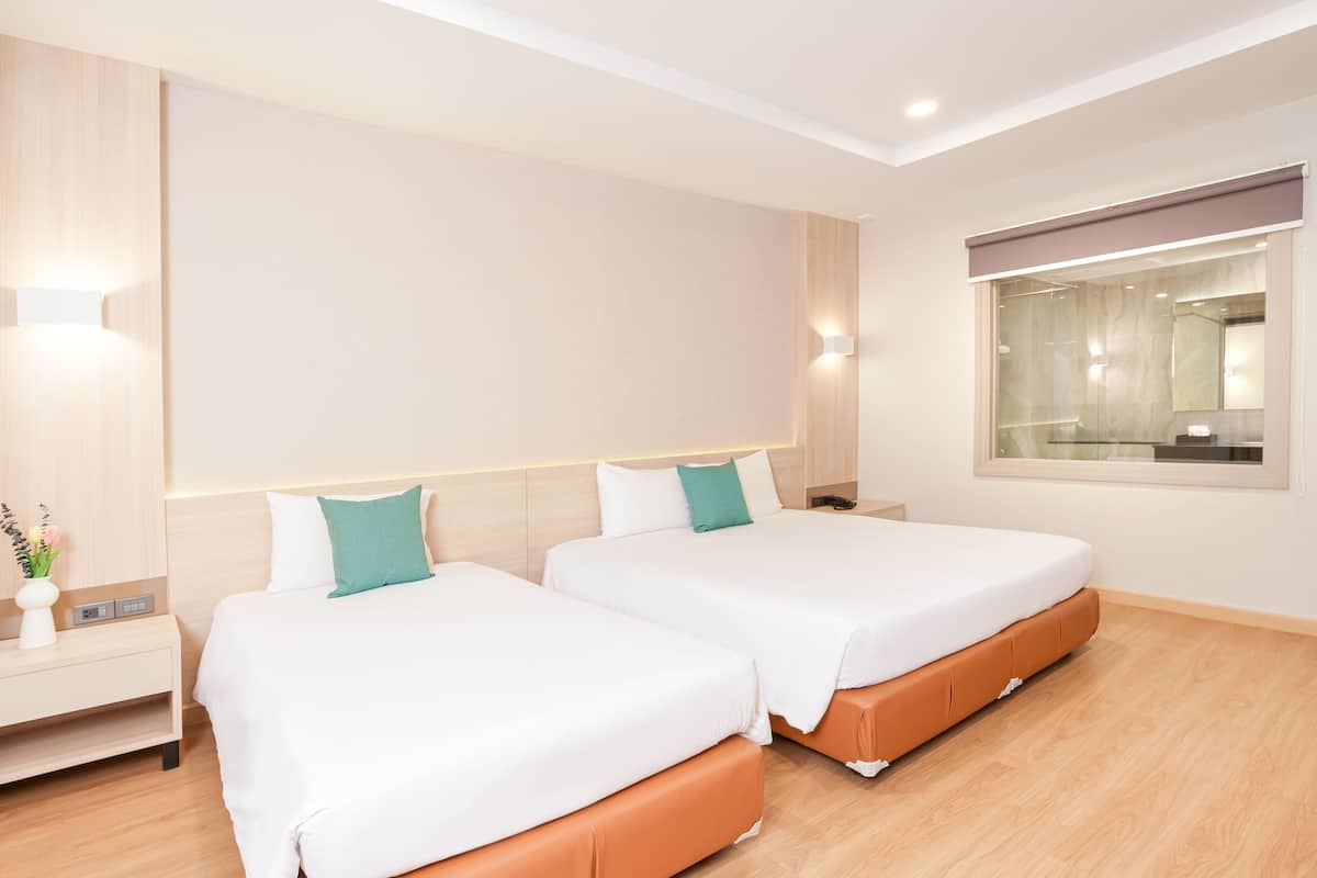 A modern hotel room with two beds, a nightstand, and a large window.