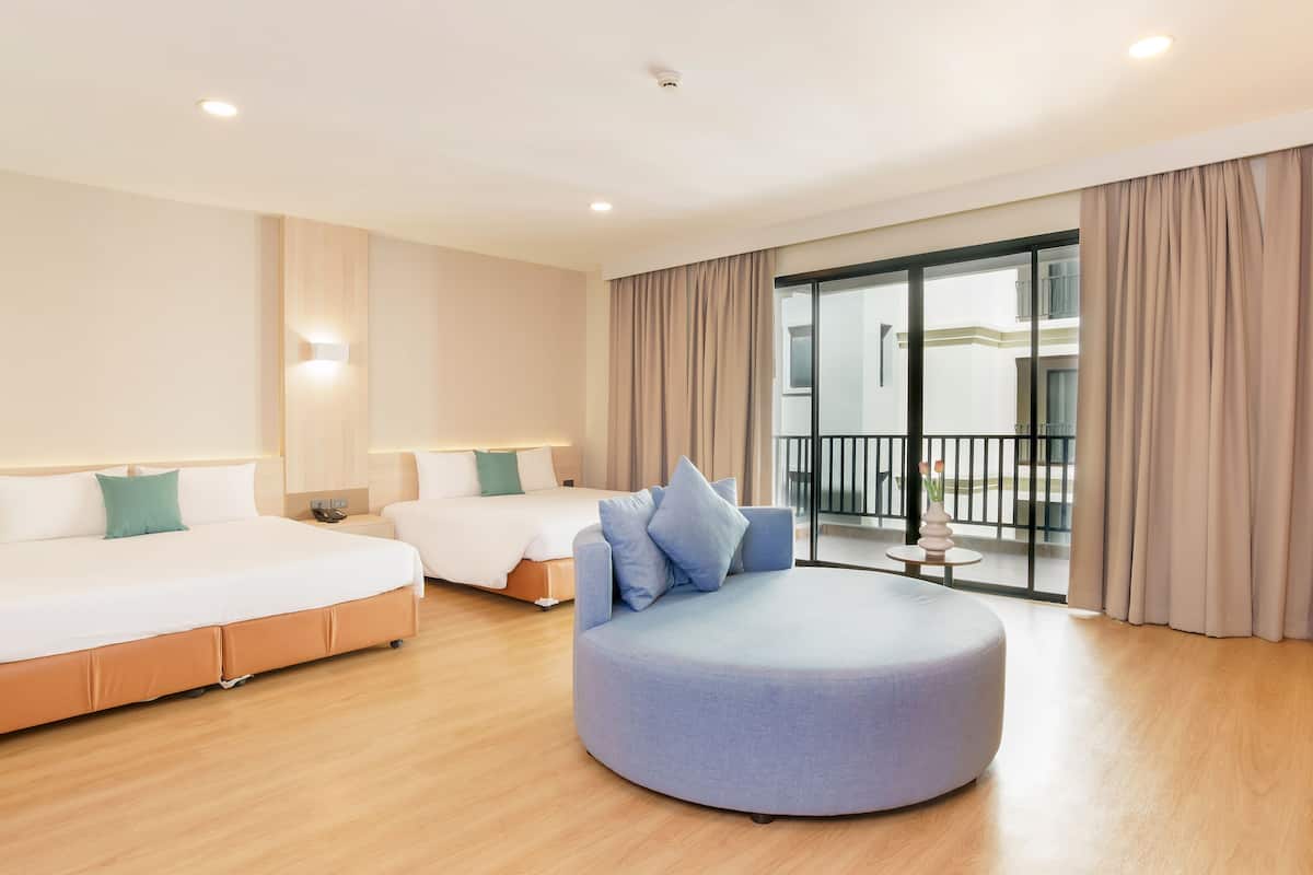 A modern hotel room with two beds, a round seating area, and a balcony with curtains.