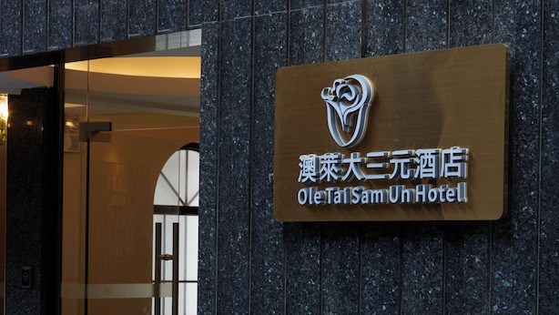 The exterior of the Ole Tai Sam Un Hotel with a signboard displaying the hotel's name and logo. - Ole Tai Sam Un Hotel (Macau)