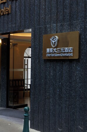 El exterior del hotel Ole Tai Sam Un, con un cartel que muestra el nombre y el logotipo del hotel.