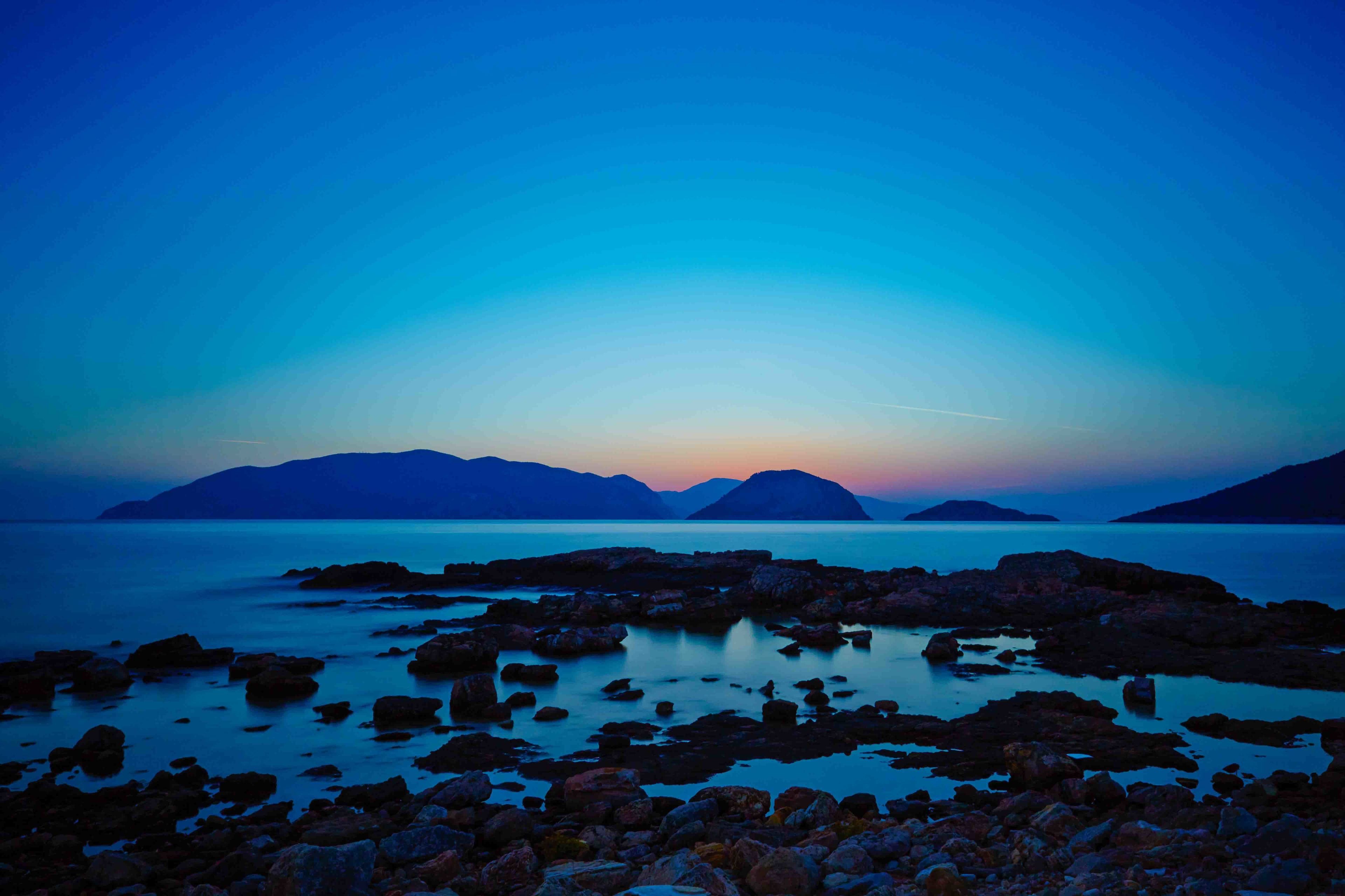 A coastal landscape with rocky shores and calm waters.
