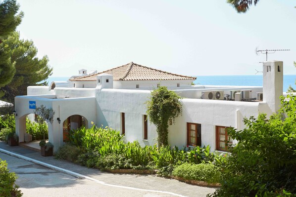 A coastal building with a tiled roof, white walls, and a view of the sea. - Marpunta Resort (Alonissos)