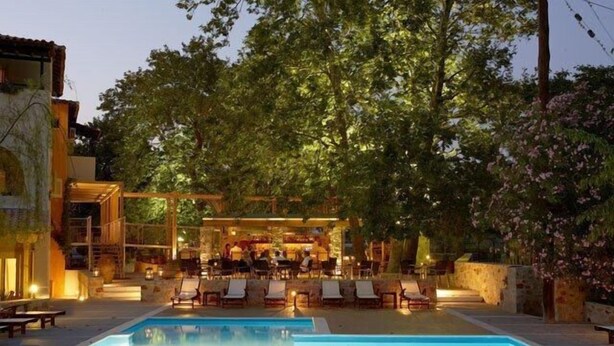 Ein Poolbereich mit Liegestühlen und eine Bar mit Tischen und Stühlen.