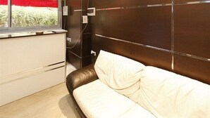 A modern room with a sofa, a window with red curtains, and a wall-mounted TV. - Dar El Ikram (Algiers)