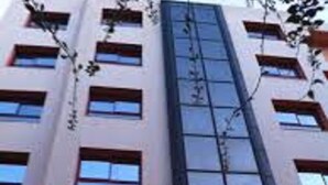 A multi-story hotel with a modern facade, featuring a central vertical glass elevator shaft and multiple windows on each floor. - Dar El Ikram (Algiers)