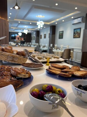 Buffet de l'esmorzar amb diverses pastes, pa i fruita.
