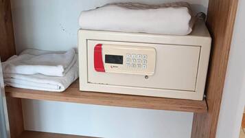 A wooden shelf unit with a microwave, folded towels, and a wooden drawer.