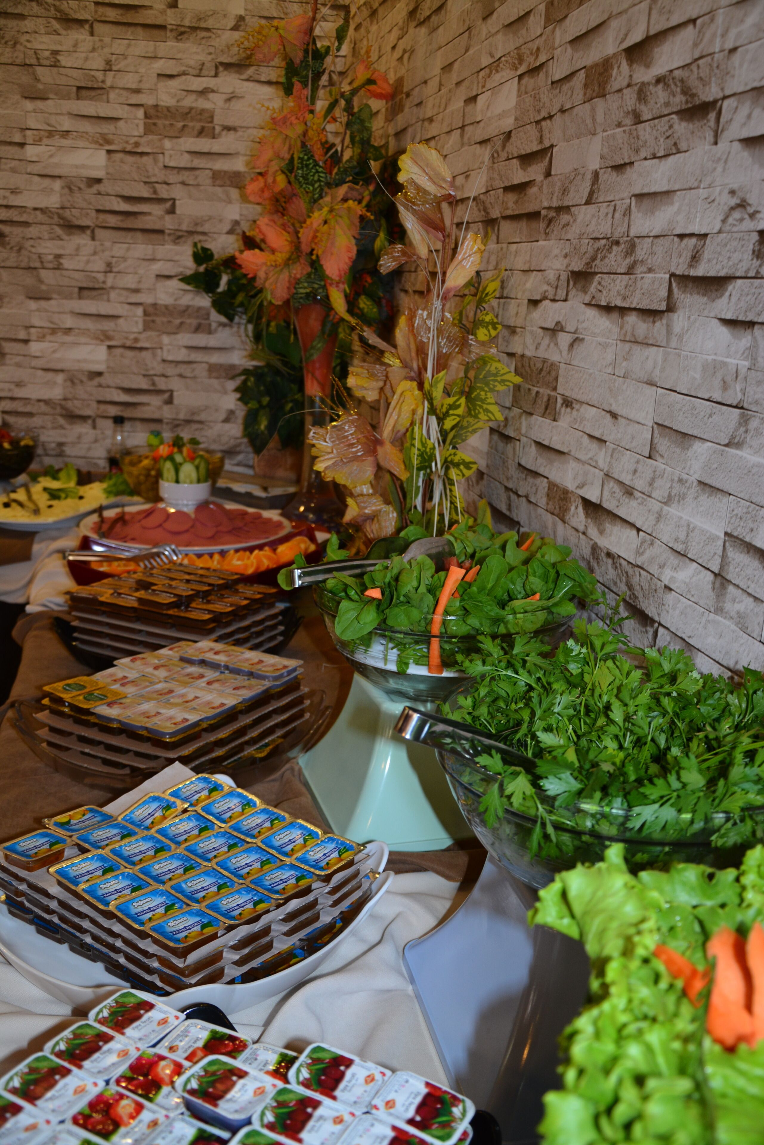 A buffet table with various food items and a decorative plant.