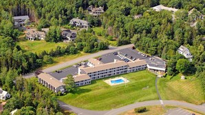 An aerial view of a hotel with multiple buildings, a parking lot, and a swimming pool. - Kimball Terrace Inn Northeast Harbor (Northeast Harbor)