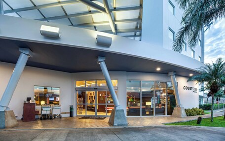 A modern building with a covered entrance, large windows, and a sign reading "COURTYARD."