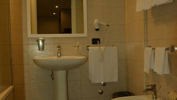 Un bagno con lavandino, bidet e wc. Sopra il lavandino c'è uno specchio e a parete un porta asciugamani.