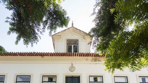 Un edificio con facciata bianca, una porta nera e una scala in pietra che conduce a un balcone.