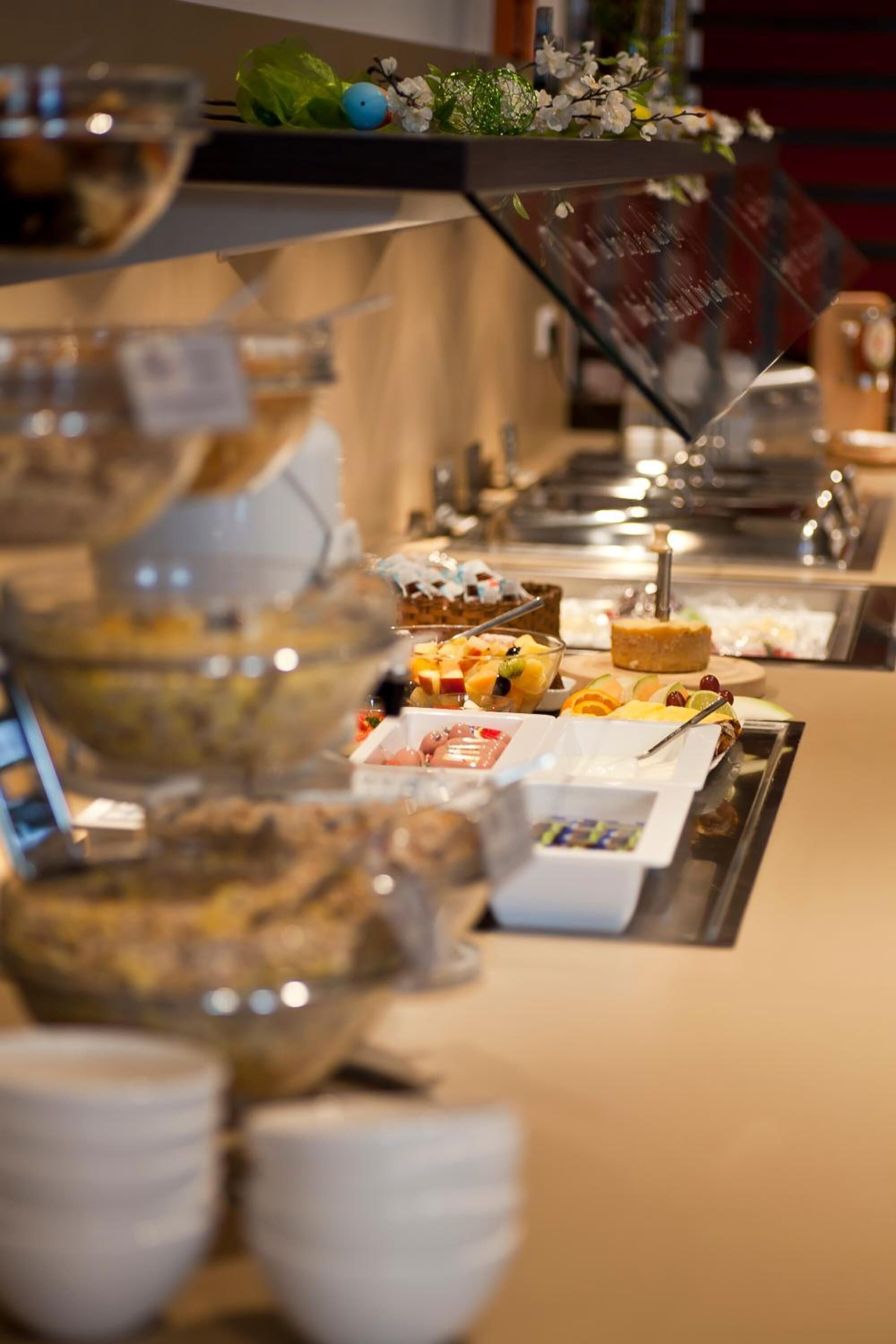 A buffet setup with various food items and a glass display case.