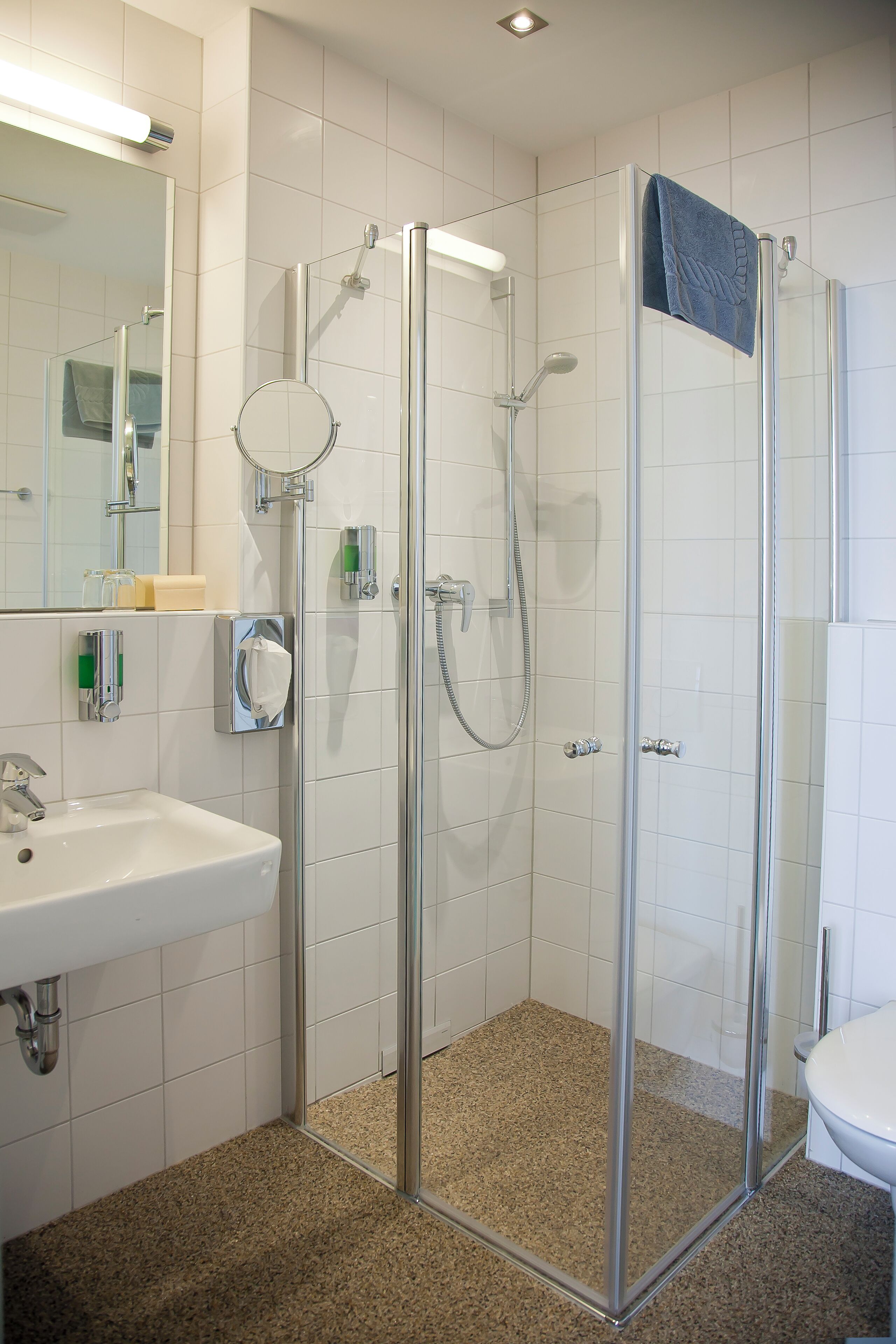 Un baño moderno con ducha de vidrio, lavamanos y inodoro.