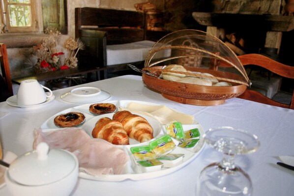 Desayuno con cruasanes, bollería y una cesta de pan.