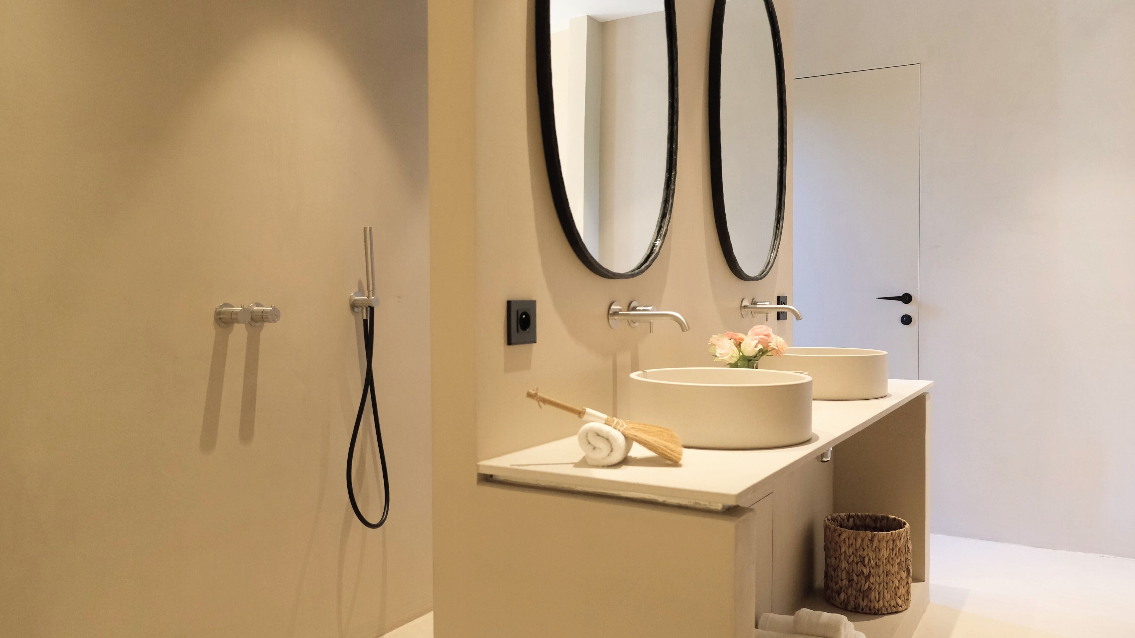 A modern bathroom with two sinks, a shower, and a toilet.