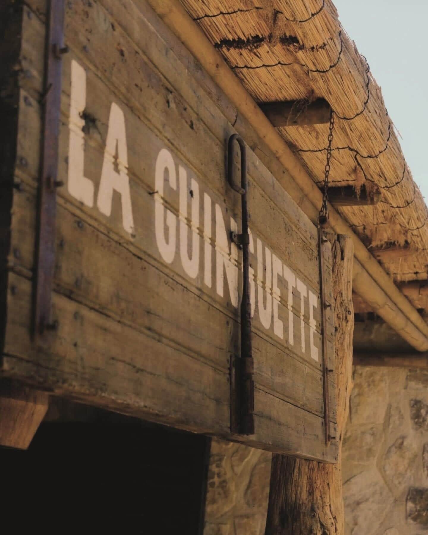 A wooden sign with the text "LA GUINOUETTE" indicating the name of a location or establishment.