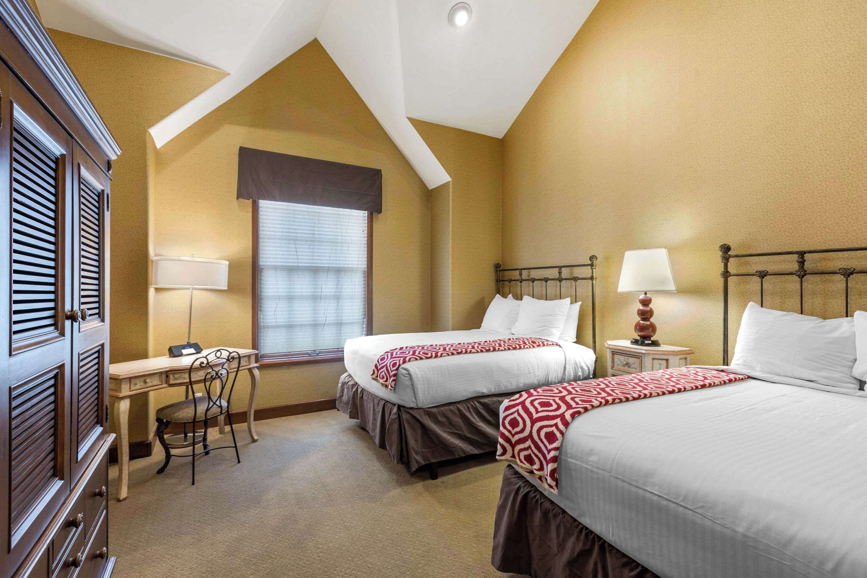 Een hotelkamer met twee bedden, een bureau en een stoel.