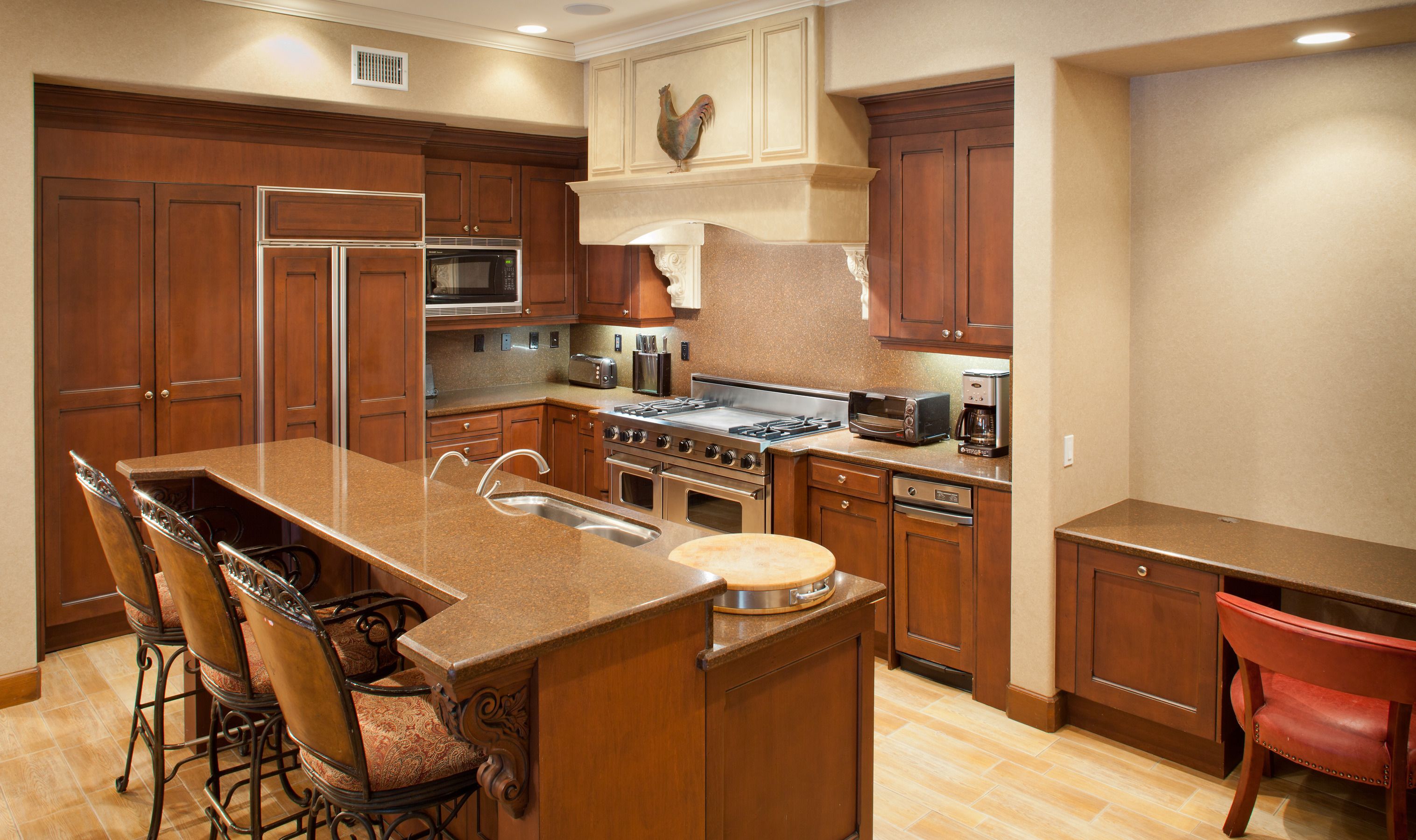 A kitchen with a central island, stainless steel appliances, and wooden cabinetry.