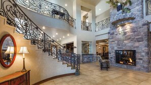 Un intérieur spacieux agrémenté d’un escalier en colimaçon, d’une cheminée en pierre et d’un coin repas.