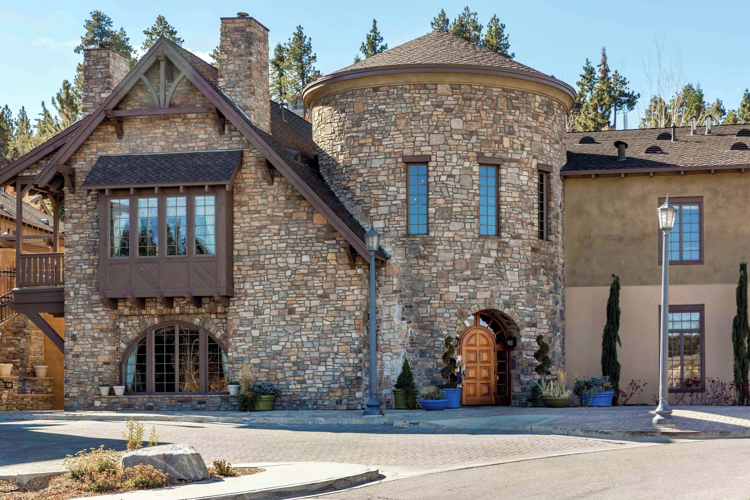 Un edificio de piedra con una torre circular, una puerta de madera y una escalera.