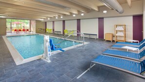 An indoor swimming pool with clear water, a diving board, and lounge chairs. - Home2 Suites by Hilton Charlotte I-77 Tyvola Rd (Charlotte)