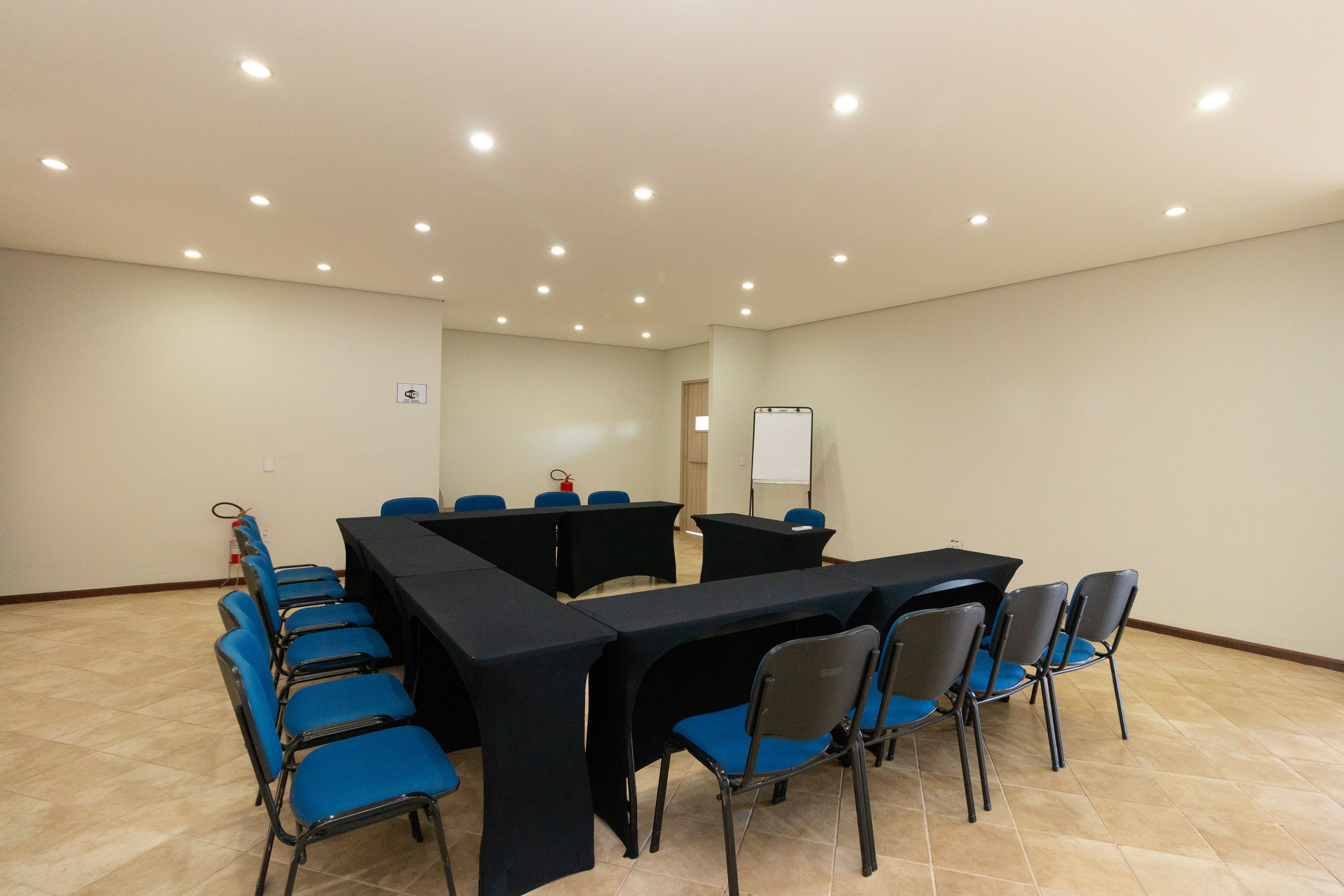A conference room with a long table, blue chairs, and a whiteboard.