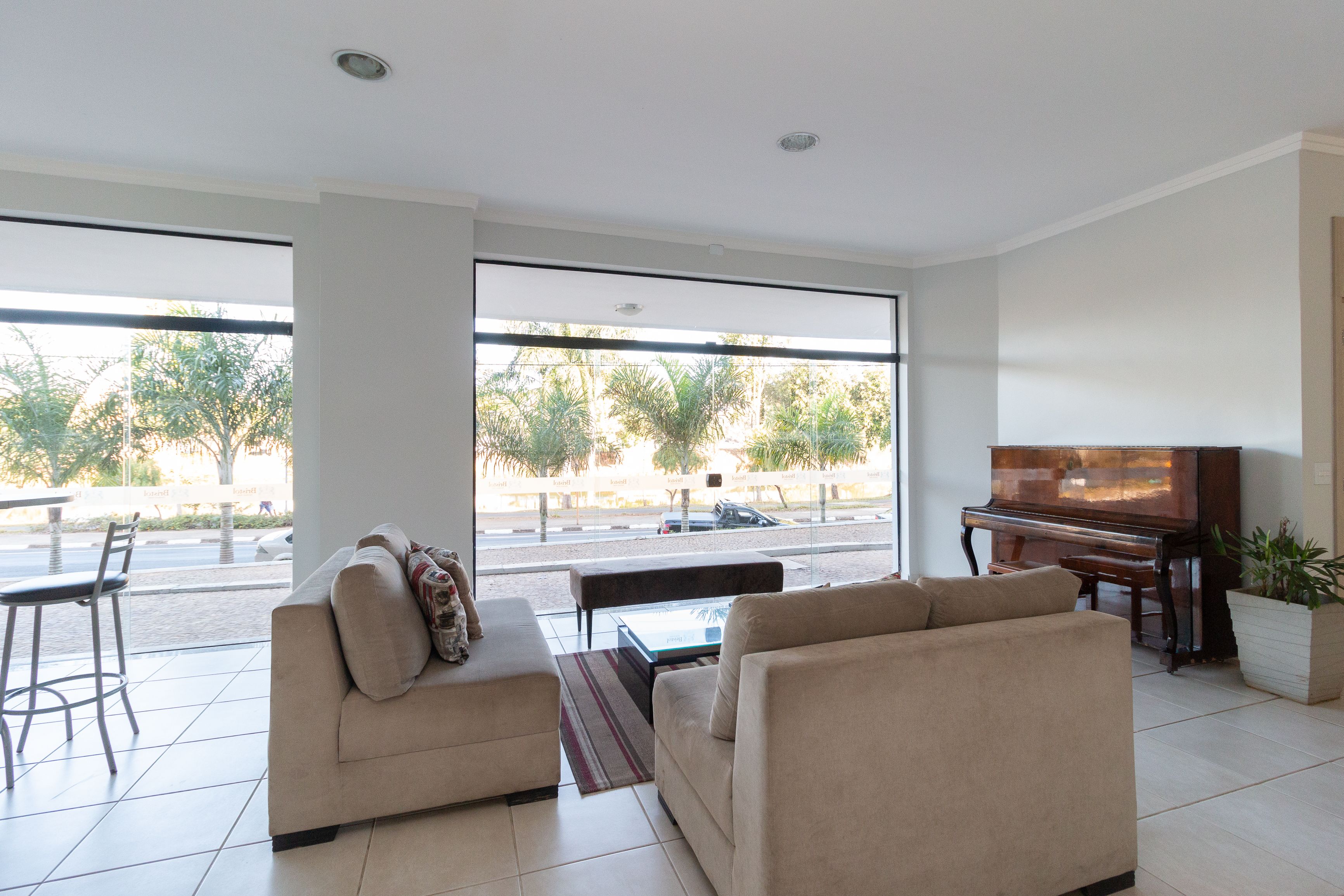 A modern living room with a sofa, a coffee table, and a piano.