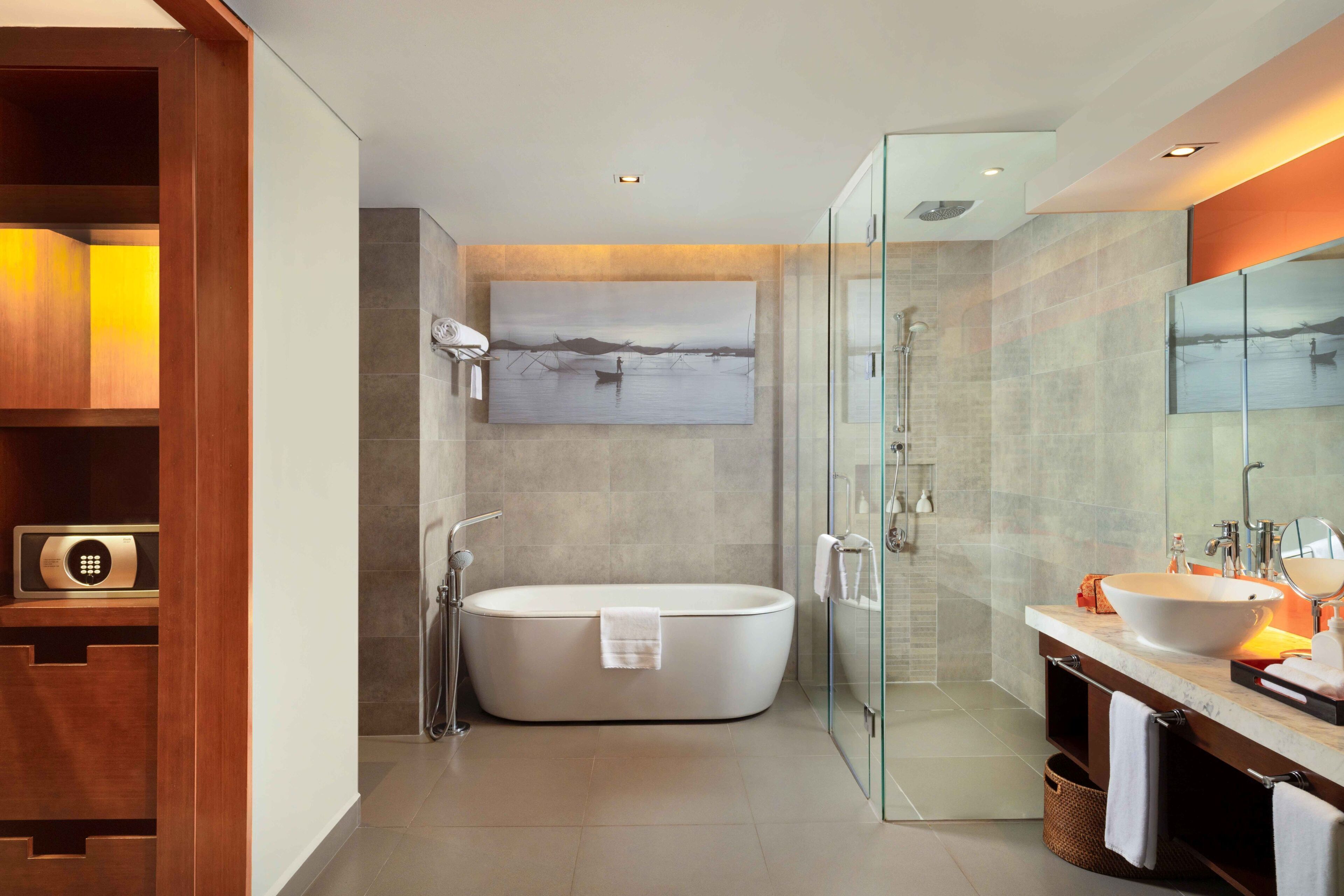 A modern bathroom with a freestanding bathtub, a glass-enclosed shower, and a vanity with a large mirror.