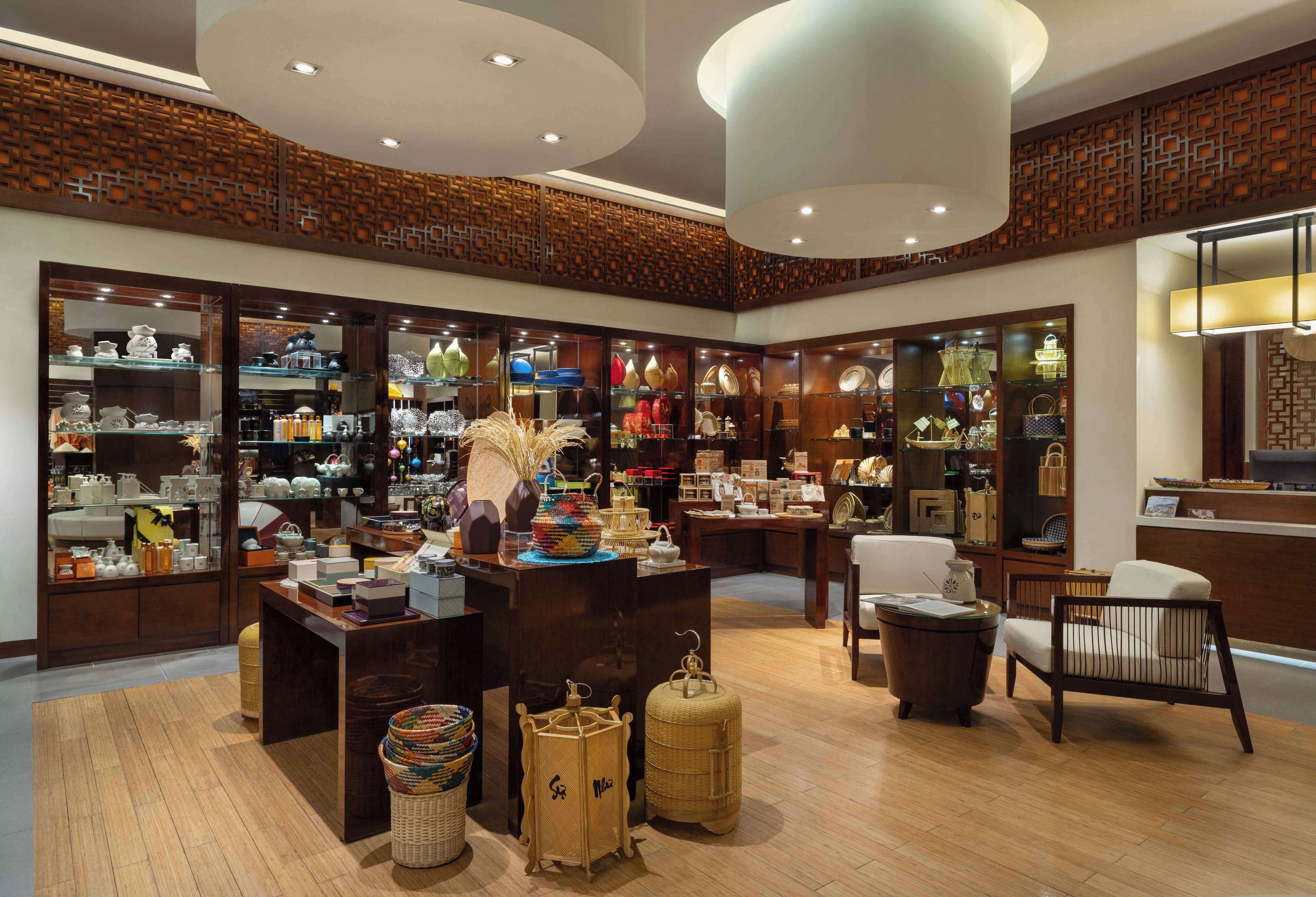 A spacious interior with wooden flooring, multiple display tables, and a variety of decorative items.