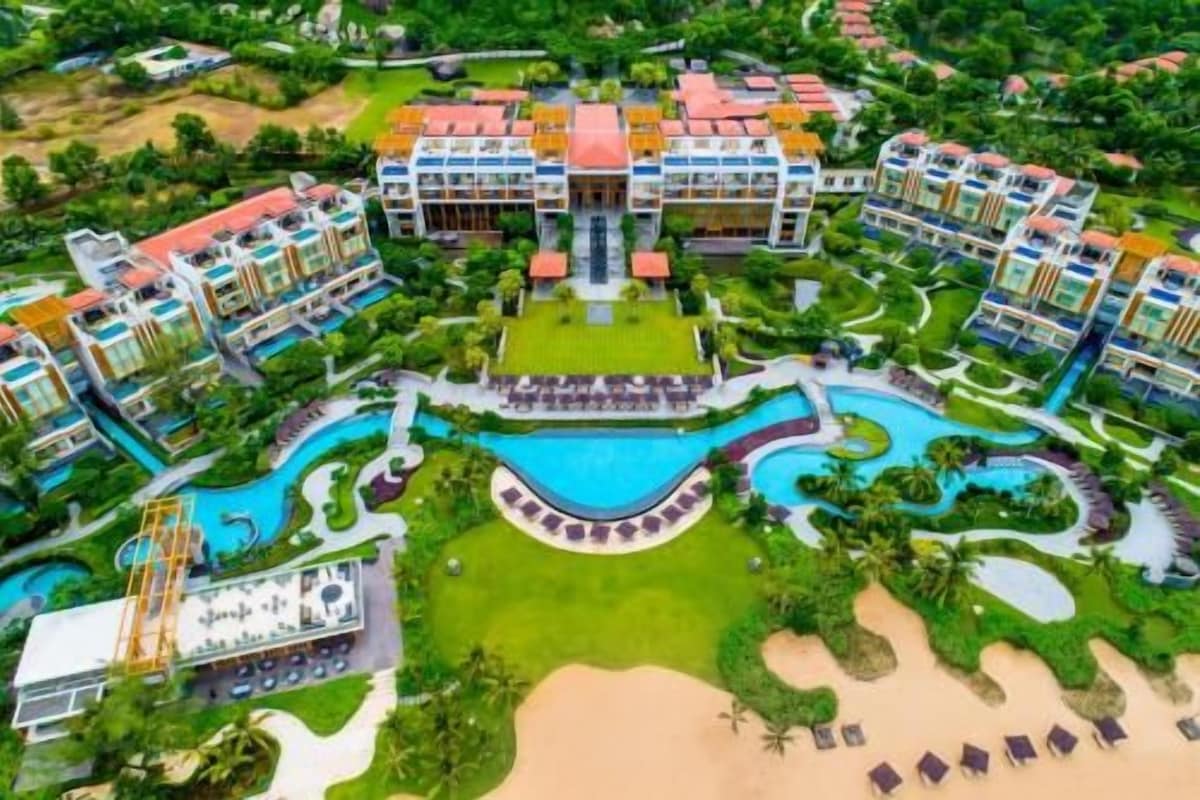 A resort with multiple buildings, a central pool, and landscaped areas.