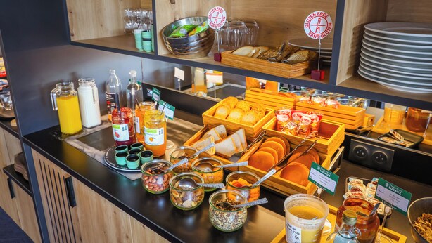 A buffet with various food items, condiments, and utensils. - Brit Hotel Le Cottage (Arnage)