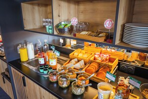 A buffet with various food items, condiments, and utensils. - Brit Hotel Le Cottage (Arnage)
