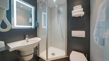 Une salle de bain moderne avec une douche à parois de verre, un lavabo et des toilettes.