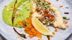 A plate with a fish, avocado, and a slice of lemon. - Brit Hotel Le Cottage (Arnage)