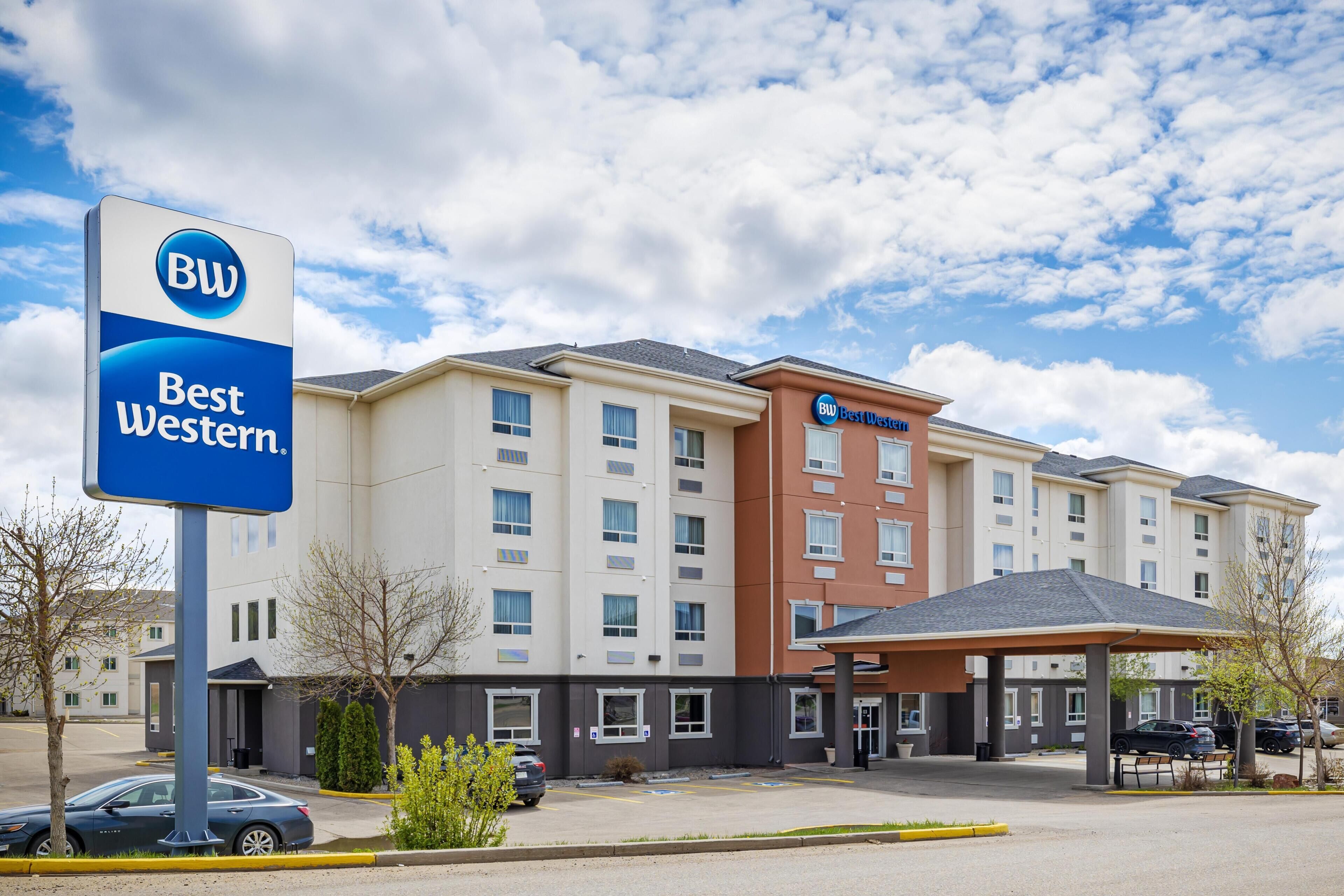 Ein Best Western Hotel mit großem Parkplatz, überdachter Eingang und einem mehrstöckigen Gebäude mit Flachdach.