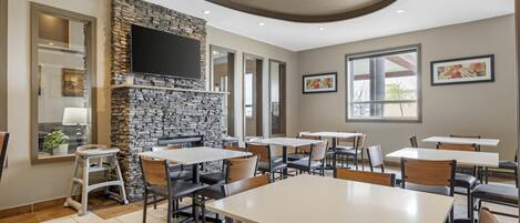 Un restaurante con paredes de piedra, varias mesas y sillas.