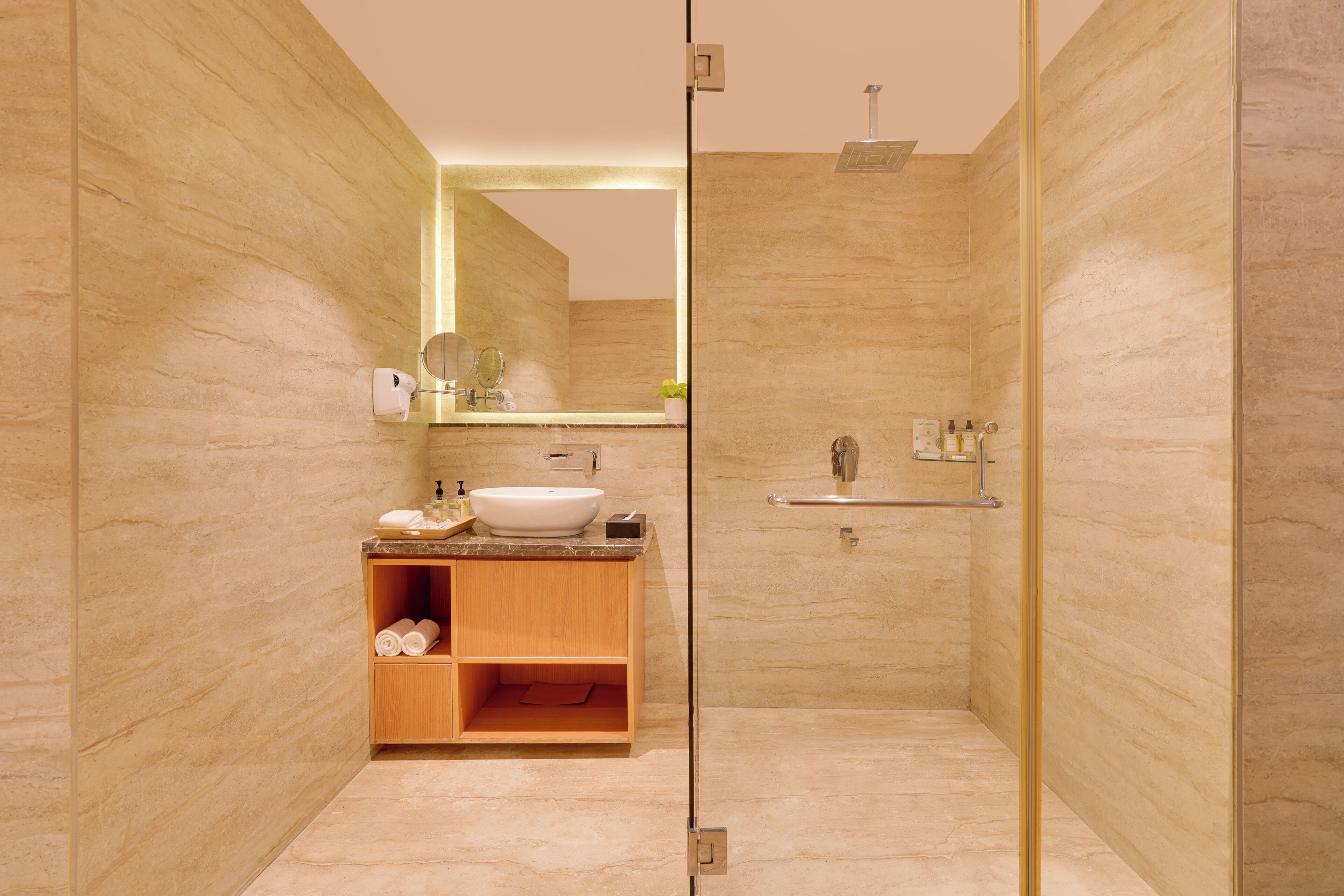 Ein modernes Badezimmer mit einer Duschkabine aus Glas, einem Holzbadezimmer-Möbelstück mit Waschbecken und einem Spiegel.