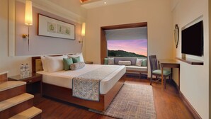 A bedroom with a bed, bedside table, chair, and a TV. - Lemon Tree Resort, Mussoorie (Dehradun)