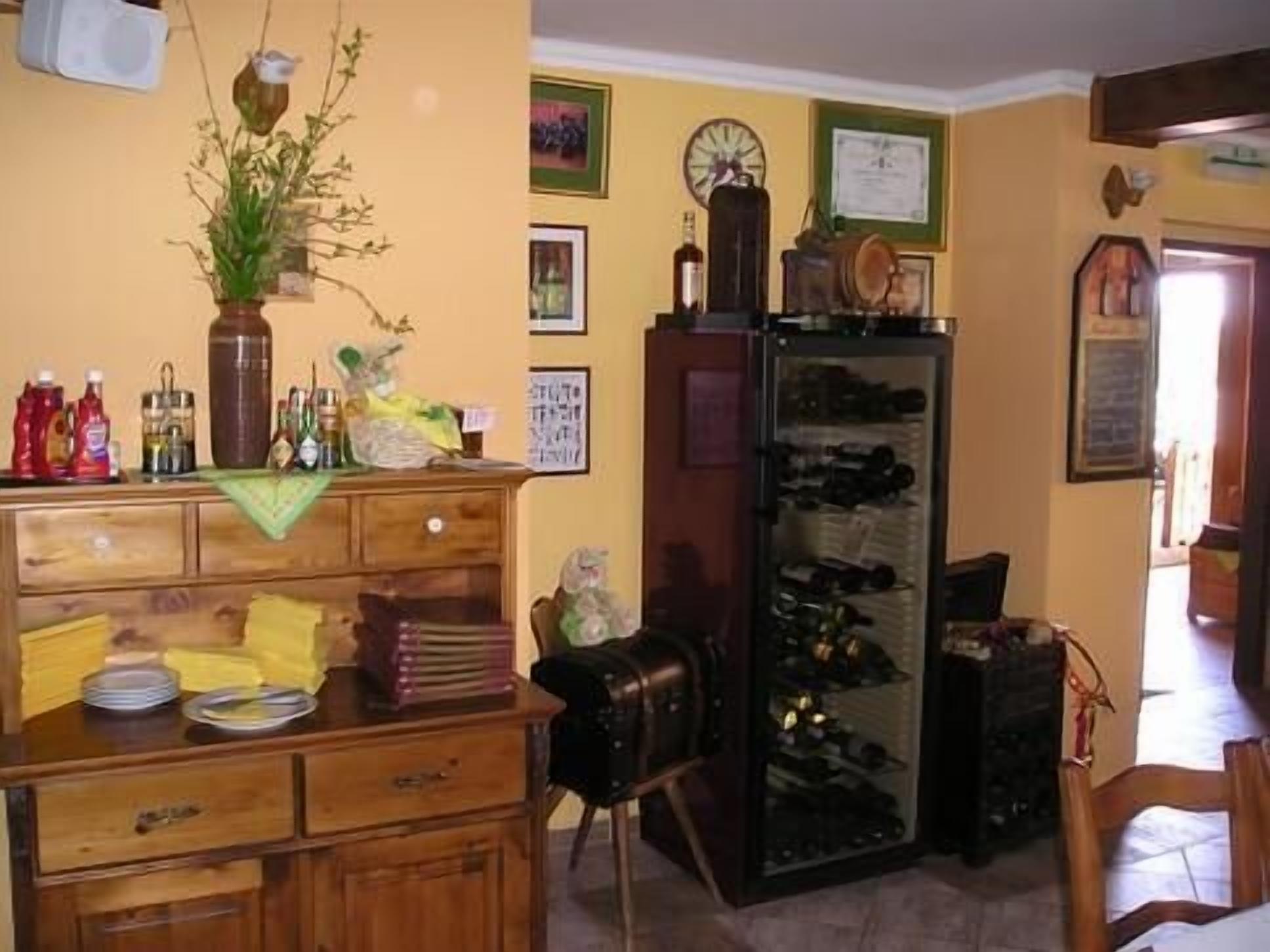 A kitchen with wooden cabinets, a refrigerator, and a clock on the wall.