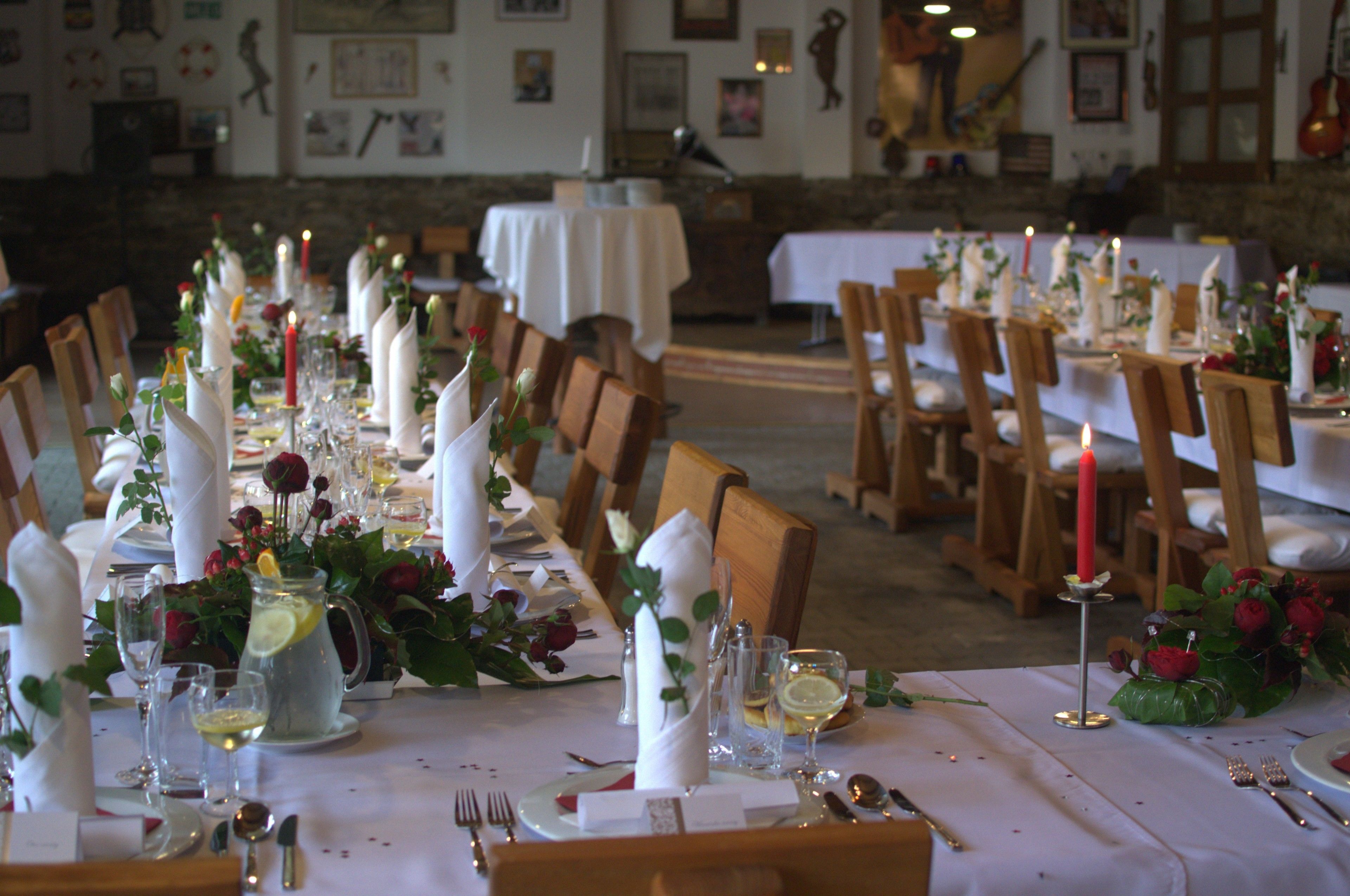 A long dining table set with white tablecloths, candles, and floral centerpieces.