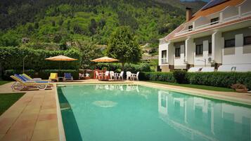 Una piscina al aire libre, tumbonas